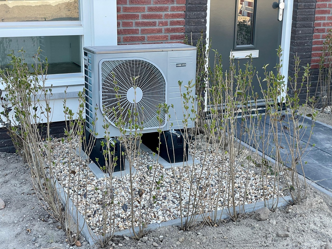 Modernes Wärmepumpen-Außengerät an einem sanierten Einfamilienhaus